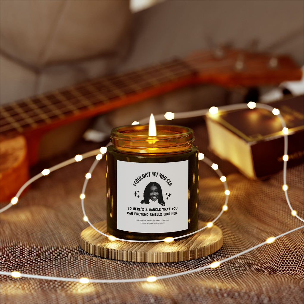 Decorative lights enwrapping a brown candle jar with a picture of SZA and some words on the front.